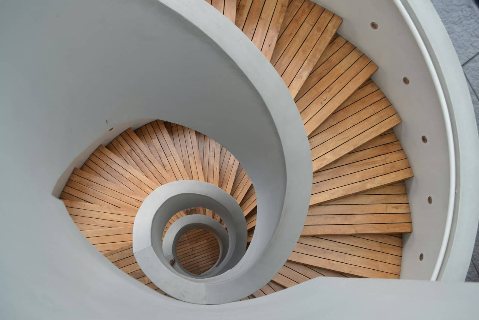 Un escalier en colimaçon aux marches de bois, vu d’en haut