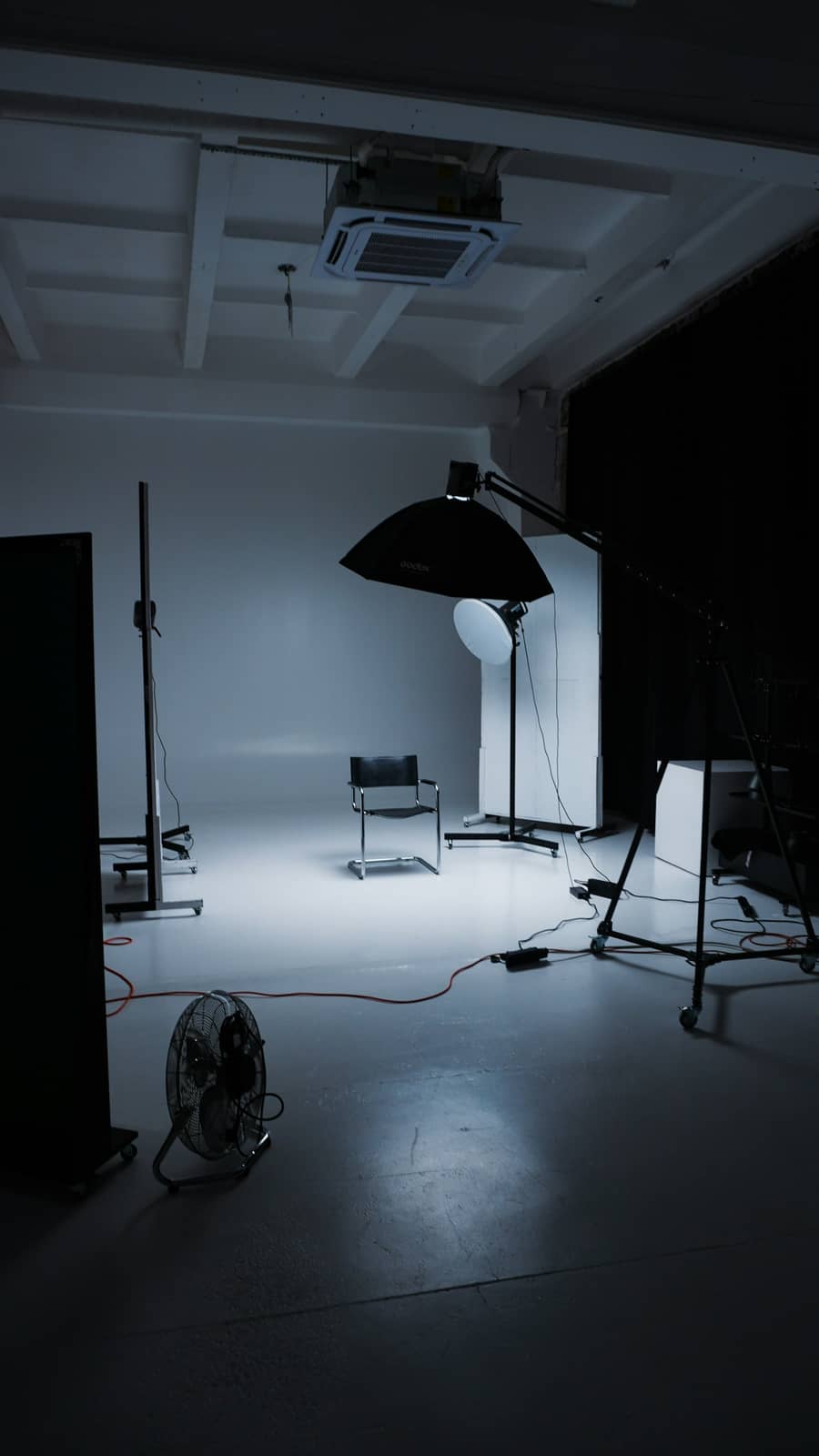 Le studio dans le noir, une chaise sous les éclairages