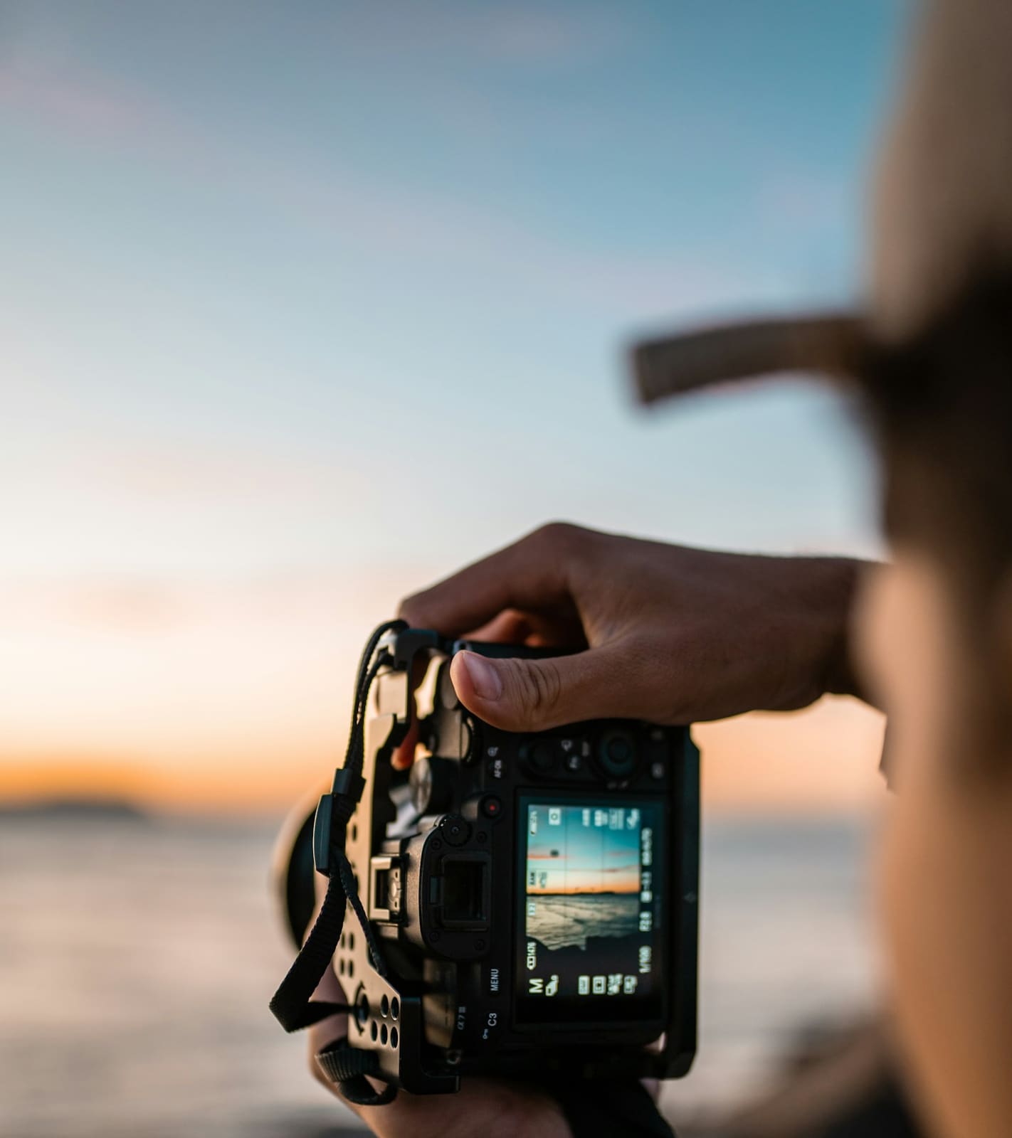 Un appareil photo levé face à la mer, au coucher du soleil